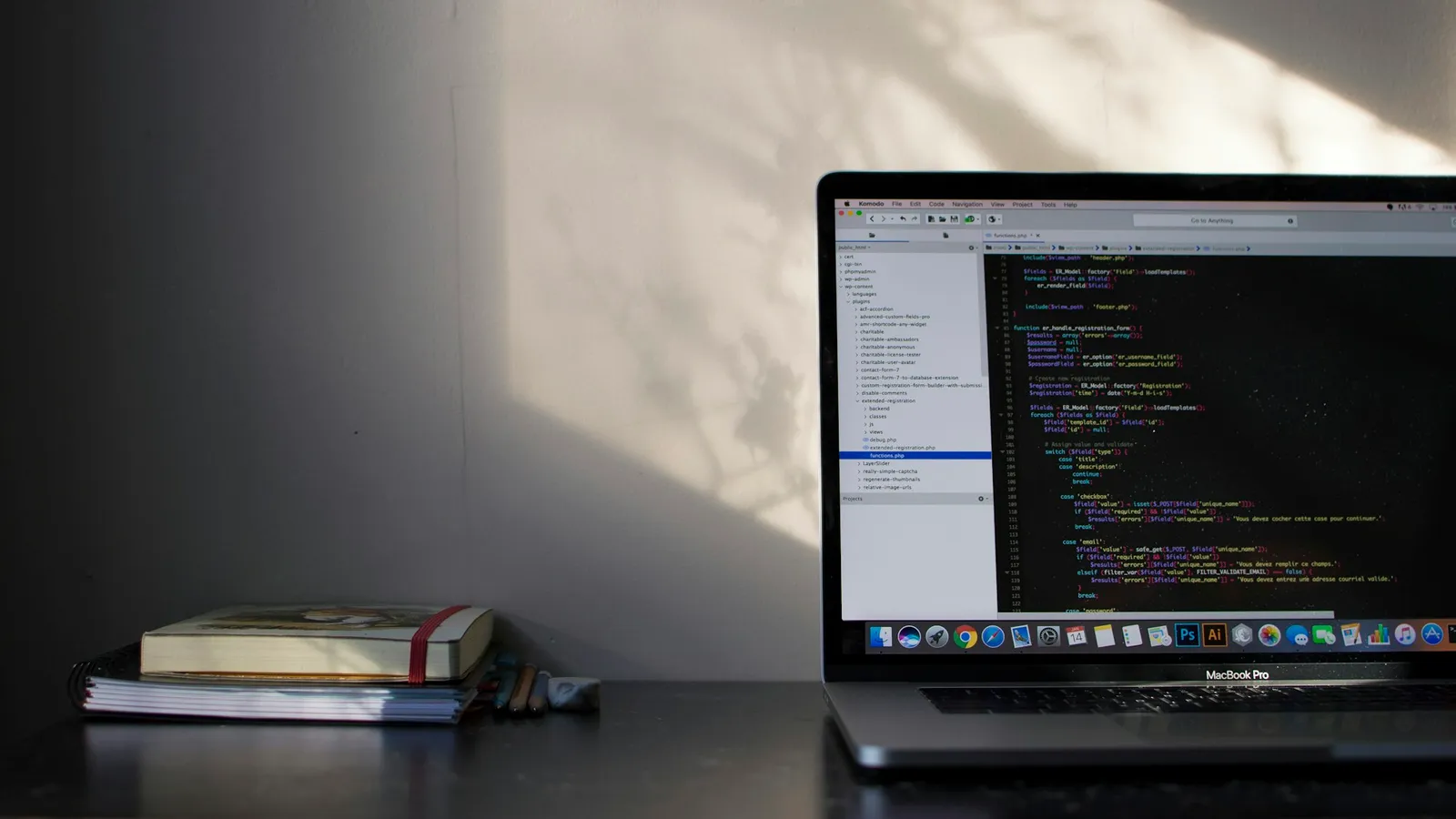A laptop showing code on a sunlit desk