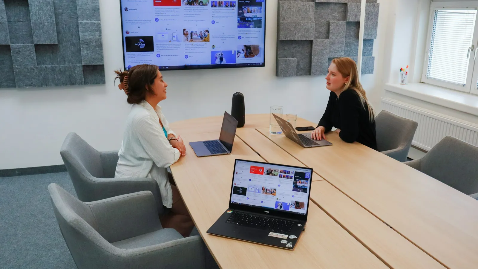 Two people in a meeting room on a video call